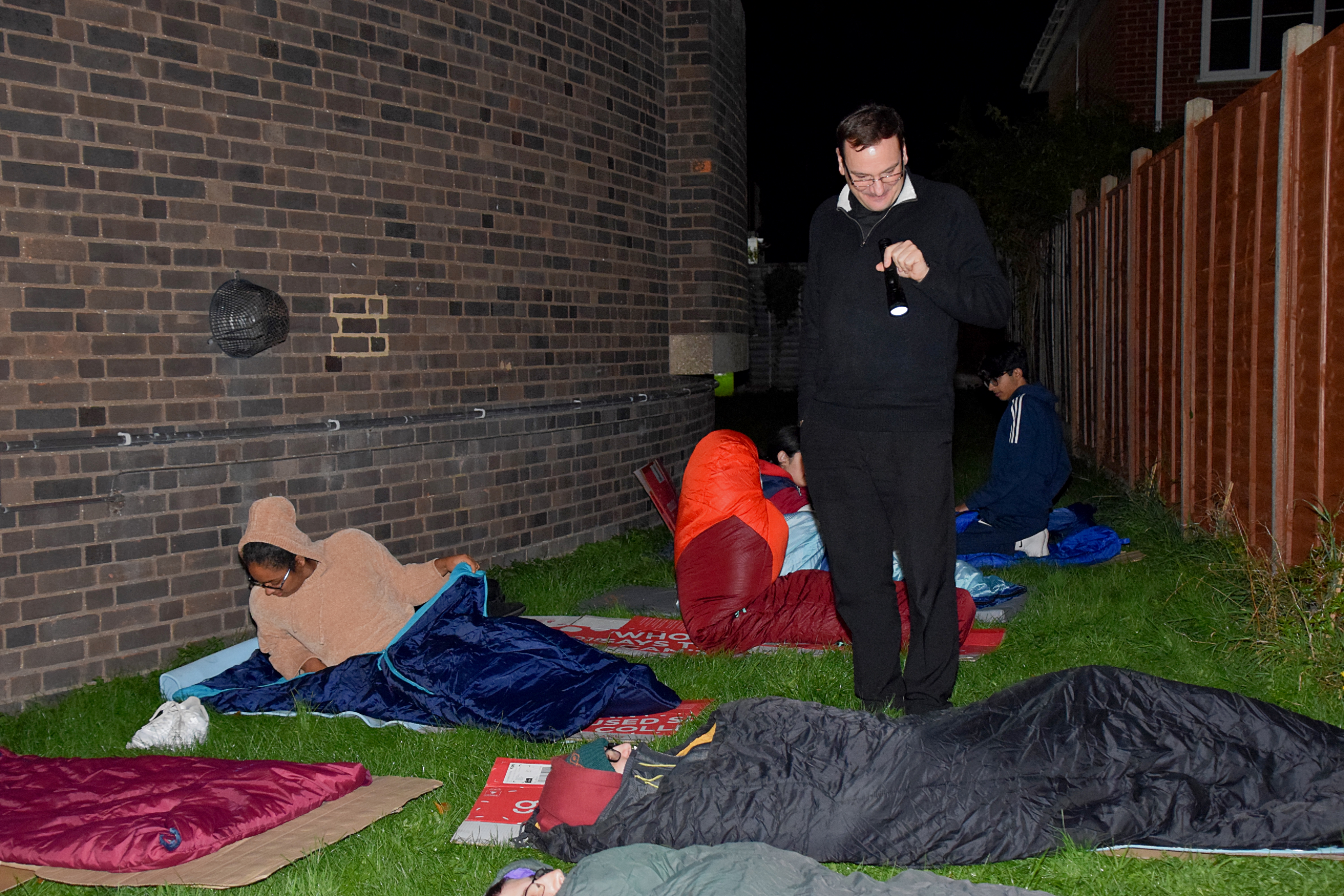 Fr Paulo helps tuck-in the B-Attitudes for their sleep out.